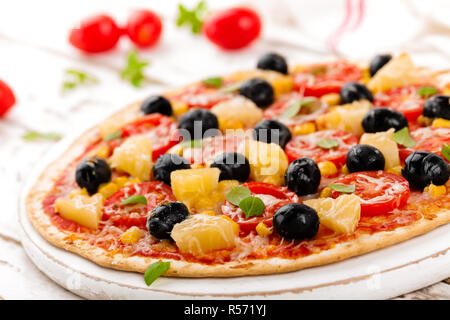 Pizza mit Tomaten, Mozzarella, Oliven, Mais und Basilikum. Traditionelle italienische Küche Stockfoto