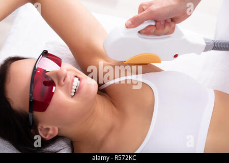 Schöne junge Frau in den Achselhöhlen und der Laser Haarentfernung Behandlung im Spa Stockfoto