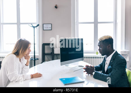 Afrikanische amerikanische und kaukasische Manager Office Tabelle kommunizieren. Schwarzer Mann hören mit Aufmerksamkeit zu Kollegen sprechen in den Unternehmen treffen. Stockfoto