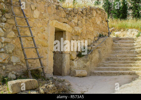 Retro Style Steinhaus im Freilichtmuseum von Nazareth Village Israel. Häuser in der modernen Nazareth im Hintergrund gesehen werden kann. Diese Seite gi Stockfoto