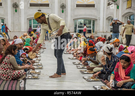 Menschen in langar (Essen) bei Gurudwara Bangla Sahib Sikh Haus der Anbetung, Delhi, Indien Stockfoto