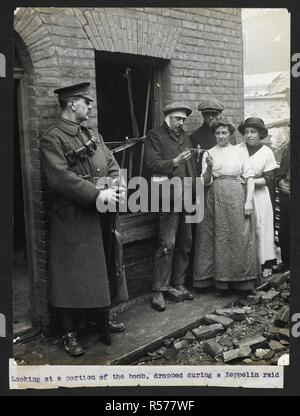 Blick auf einen Teil eines Zeppelin Bombe, fiel während einer RAID-[England]. Zivilisten außerhalb eines Hauses posiert, ein Soldat im linken Vordergrund. Aufzeichnung der indischen Armee in Europa während des Ersten Weltkrieges. Jahrhunderts, 1915. Gelatine Silber gedruckt. Quelle: Foto 24 / (26). Sprache: Englisch. Autor: Dhaka, H. D. Stockfoto