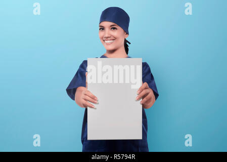 Lächelnd asiatische Frau Krankenschwester zeigt leeres Papier Stockfoto