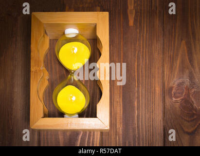 Holz- Retro sand Glas Wecker liegen auf der Seite mit dem Sand auf Holz- Hintergrund. zeit-Konzept. Stockfoto