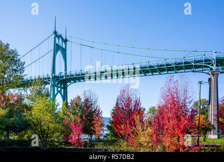 Beliebte gothic St Johns Brücke mit Dunst über den Willamette River in Portland im industriellen Bereich mit gewölbten Stützen im Herbst rot umgeben Stockfoto