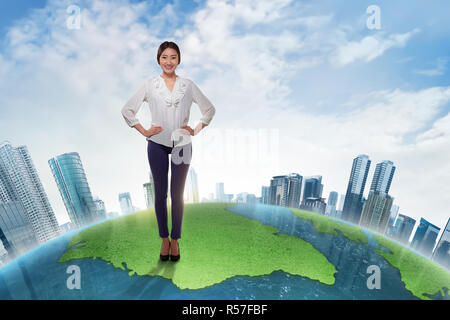 Attraktiven asiatischen Business woman stehen auf große Masse mit Wolkenkratzern Stockfoto