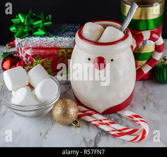 Santa Claus Becher mit heißer Schokolade und Marshmallows mit Zuckerstangen und Pfefferminze Sticks präsentiert Satinschleifen und Frische Marshmallows Stockfoto