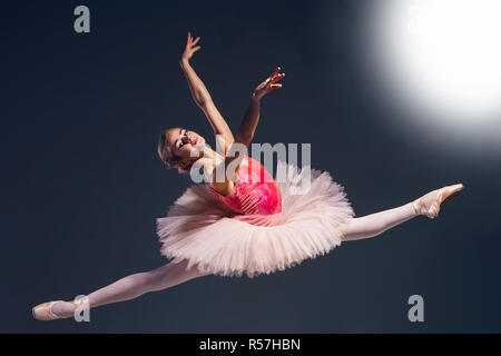 Schöne weibliche Ballett-Tänzerin auf einem dunklen Hintergrund. Ballerina trägt rosa Tutu und Pointe Schuhe. Stockfoto