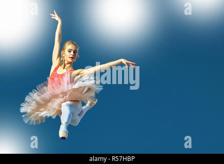Schöne weibliche Ballett-Tänzerin auf einem grauen Hintergrund. Ballerina trägt rosa Tutu und Pointe Schuhe. Stockfoto