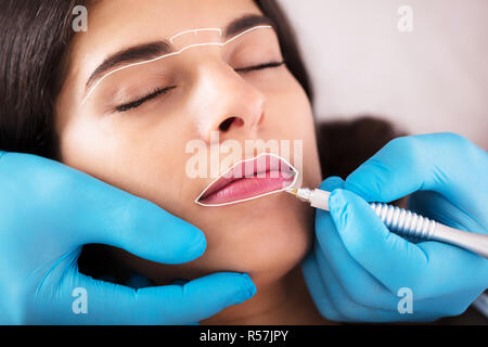 Kosmetiker Anwendung Permanent Make Up an Lippen Stockfoto