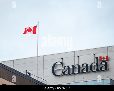 OTTAWA, Kanada - 10. NOVEMBER 2018: Kanada Wortmarke, das offizielle Logo der kanadischen Regierung, auf eine administrative Gebäude neben einer kanadischen Fl Stockfoto