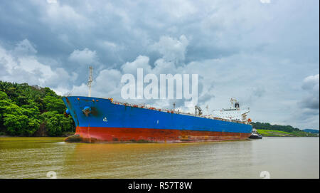 Ein großes Frachtschiff macht seinen Weg durch den Panamakanal Wasserstraßen, auf jeder Seite zwischen den Schleusen mit grünen Regenwald Dschungel flankiert wird. Stockfoto