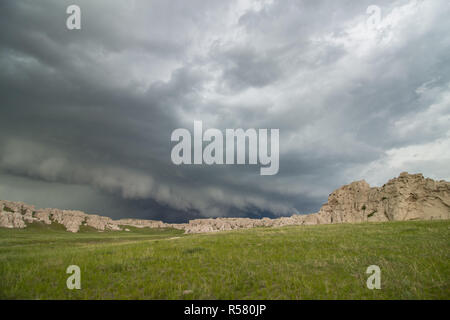 Eine niedrige und ominöse Shelf cloud Ansätze felsigen Klippen auf einem Hügel in Nebraska. Stockfoto