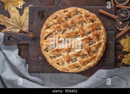 Ganze runde Apfelkuchen auf einem rechteckigen alte braune Board gebacken, Holztisch, Ansicht von oben Stockfoto