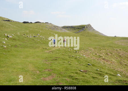 Zwei Wanderer wandern in den Mooren entlang der Dales Weg Wanderweg in Yorkshire, England, Vereinigtes Königreich. Stockfoto