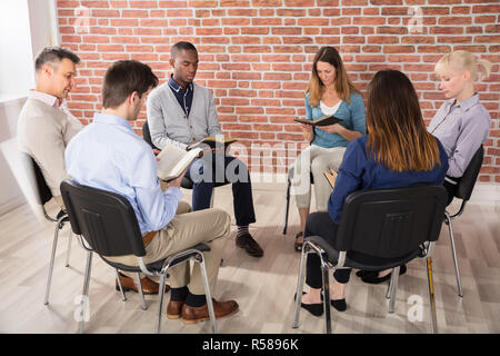 Gruppe von Menschen lesen Bibeln Stockfoto