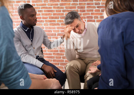 Afrikanischer Mann seinen Freund trösten. Stockfoto