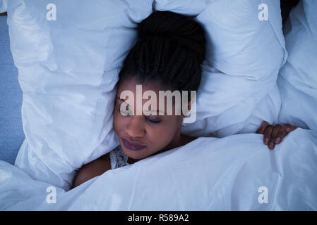 Junge Frau auf Bett schlafen Stockfoto