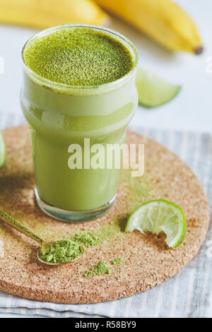 Ein Glas mit einem grünen Smoothie mit Banane, Hafermilch, Kalk und Matcha Tee. Das Konzept der vegetarische und gesunde Ernährung Lebensmittel. Stockfoto