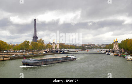 Eiffel-Turm am Ufer des Flusses Seine mit Schiff Frühling bewölkten Tag Stockfoto