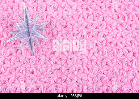 Schneeflocke Christbaumschmuck auf Rosa gestrickt Serviette geprägt. Stockfoto