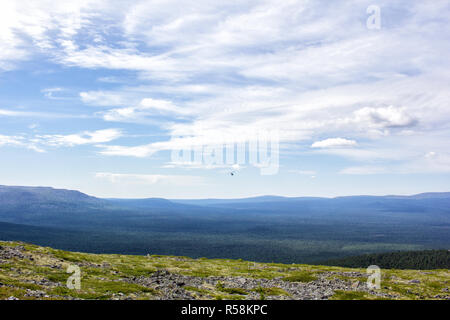 Ein Hubschrauber fliegen in den Himmel über den Bergen. Wunderschöne Landschaft. Stockfoto