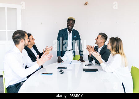 Multirassischen Geschäft Leute applaudieren am Konferenztisch, vielfältiges Team Händeklatschen nach Treffen der Gruppe Stockfoto