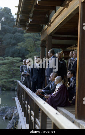 1974, November 21 - Schloss Kinkakuji (goldener Pavillon) - Kyoto, Japan - Gerald R. Ford, Zen-buddhistischen Abt Jikai Murakami, Dolmetscher, Außenminister Henry A. Kissinger, Donald Rumsfeld; andere Mitglieder der US-amerikanischen und japanischen Gruppe Reisen - Ein Dolmetscher sitzt zwischen Präsident Ford und zen-buddhistischen Abt Jikai Murakami als die beiden Chat im Pavillon über dem Cyoko Chi Teich - das erste Mal in Japan durch eine Sitzung des US-Präsidenten - Tour der zen-buddhistisches Heiligtum - Abbott von Gold Pavillon Stockfoto