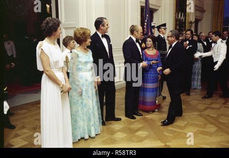 1976, Juli 27 - Osten - das Weiße Haus - Gerald R. Ford, Betty Ford, Malcolm Fraser, Tamara Fraser; Henry Kissinger, Shirley Temple Black - Gruß, Händeschütteln, stehend, spreche; formale Abnutzung - Erhalt der Linie für nach dem Abendessen an der Staatlichen Abendessen für die Premierminister von Australien Stockfoto