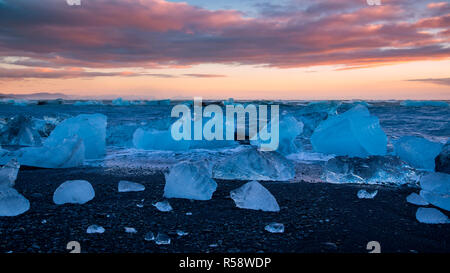 Sonnenaufgang über dem schwarzen Sandstrand im Süden Islands, Jökulsarlon, Island Stockfoto