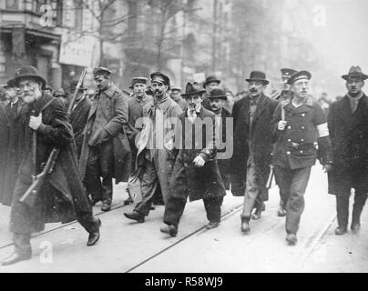 Deutsche Revolution - Sparticides, ein ausgefranstes Soldat, einer bewaffneten Seemann, einige junge Männer, und einen alten Kollegen führen die Gruppe mit einem Gewehr Ca. 1919 (Wandern im Schnee) Stockfoto