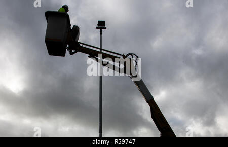 Carrigaline, Cork, Irland. 30. November 2018. Eine Airtricity Ingenieur bereitet neue Flutlichtanlage auf dem Basketballplatz in der Gemeinschaft Komplex in Carrigaline, Co Cork, Irland zu installieren. Quelle: David Creedon/Alamy leben Nachrichten Stockfoto