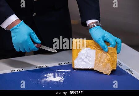 Hamburg, Deutschland. 30 Nov, 2018. Während einer Pressekonferenz, einen zollbeamten öffnet sich ein Paket von Kokain durch die Beamten beschlagnahmten. Die Beamten entdeckten den 300 Kilo Drogen in einen Behälter aus der Dominikanischen Republik Anfang November. Credit: Daniel Reinhardt/dpa/Alamy leben Nachrichten Stockfoto