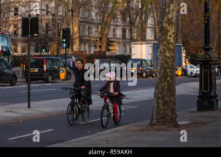 London, Großbritannien. 30 Nov, 2018. Wetter. Themse an der Böschung. Bewölkt, aber trocken. Sportboote ply bedeckten Themse mit goldenen Blätter auf den Bäumen entlang der Böschung hängen als Radfahrer ihre engagierte Autobahn mit Blackfriars Station, die Walkie-Talkie-und Käsereibe in der Ferne verwenden. Credit: Peter Hogan/Alamy leben Nachrichten Stockfoto