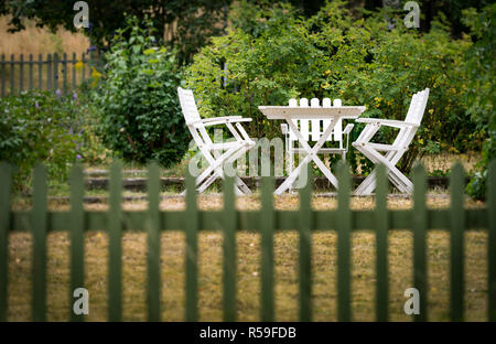 Garten Stühle und Tisch hinter Zaun Stockfoto