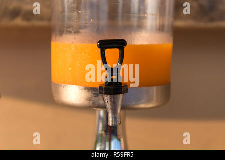 Orangensaft in Wasser Kühler für Frühstück im Hotel Stockfoto