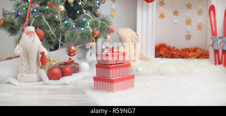 Stapel der Weihnachtsgeschenke in bunten Verpackung mit Bändern unter einem Weihnachtsbaum. Stockfoto