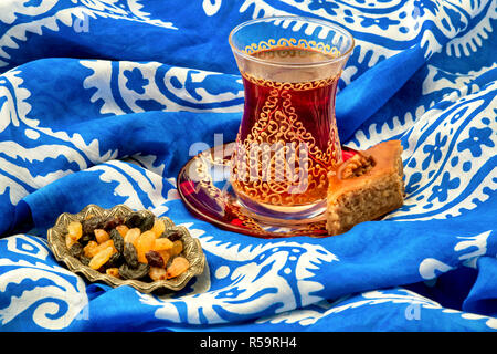 Traditionelle Armudu (Tee Tasse) mit Pakhlava und Rosinen auf einem Kelaghayi (Schal) Stockfoto