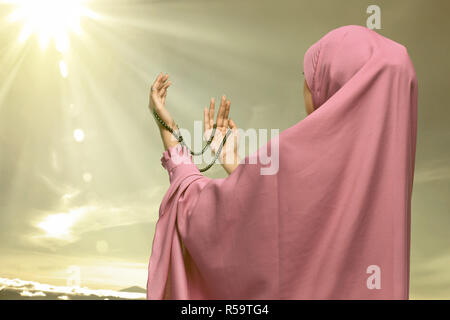 Hübsche asiatische muslimischen Frau in die Hand und Beten Stockfoto