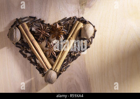 Verschiedene winter Gewürze auf einem Holz- Hintergrund als Herz, Ansicht von oben mit der Kopie Raum geformt Stockfoto