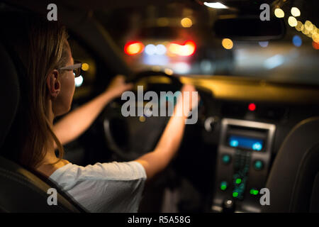 Frauen fahren Auto Fahren bei Nacht (flacher DOF Farbe getonte Bild) Stockfoto