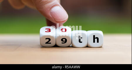 Hand würfeln und ändert die Zahl "29" in "30" Stockfoto