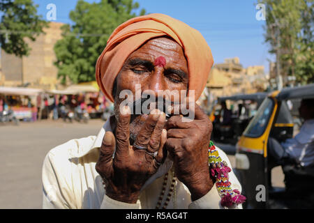 Mann spielt Mundharmonika an Mehrangarh Fort, Jodhpur, Rajasthan, Indien. Stockfoto