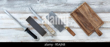 Kochen Messer mit nassen Stein und Stahl zum Schärfen auf weißen Holzmöbeln im Landhausstil Boards Stockfoto