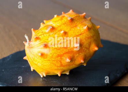 Obst Kivano (kiwano) Melone am Schwarzen Stein Schreibtisch Hintergrund. Close Up. Stockfoto