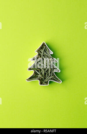 Weihnachtsbaum aus Tannenzweigen in Form von Kuchen. Weihnachtsbaum Konzept auf grünem Hintergrund. Stockfoto