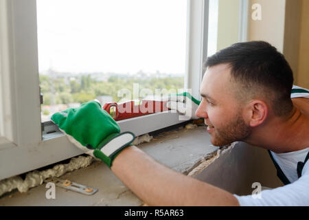 Der Mensch ist mit Hilfe einer Wasserwaage Stockfoto