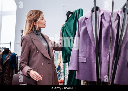Elegante Geschäftsfrau. Stilvoll elegante Geschäftsfrau durch Auswählen von "Neues grünes Kleid in Ihrer bevorzugten Boutique Stockfoto