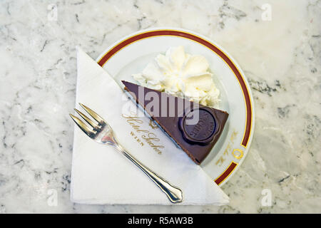 Ein Stück Original Sacher-Torte Kuchen mit Schlagsahne im Hotel Sacher, Wien, Österreich. (PR) Stockfoto