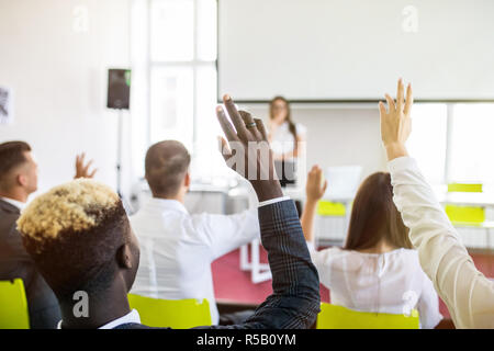 Kollegen, die eine Frage, eine Geschäftsfrau während einer Präsentation Stockfoto